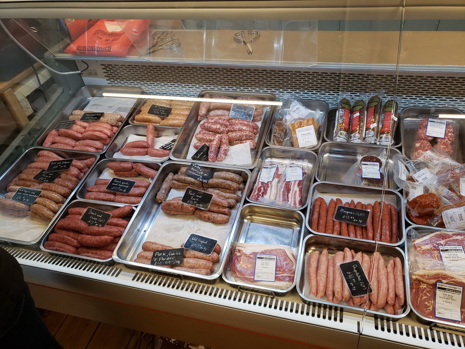 A hanging display of many cured sausages